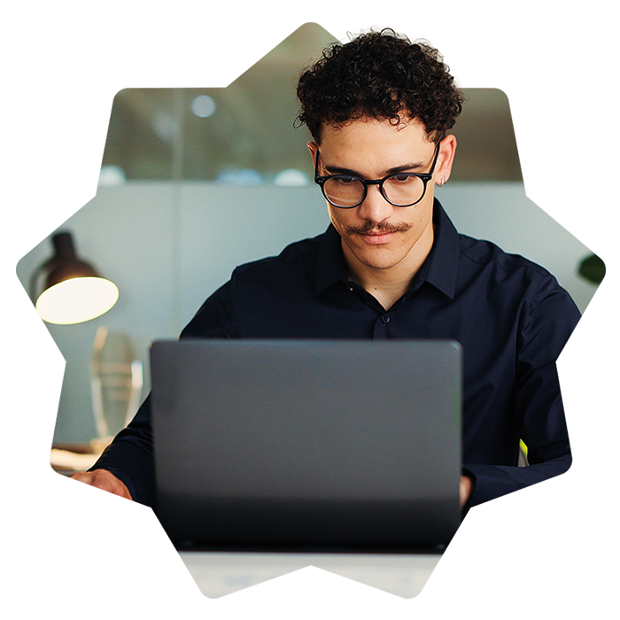 Giovane uomo concentrato sul laptop in un ufficio moderno