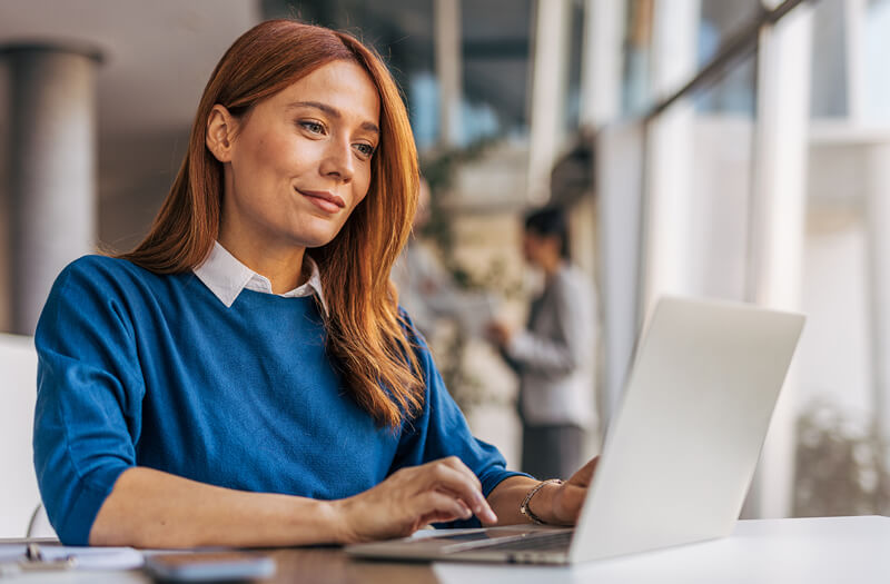 Donna d'affari che utilizza un computer portatile con Gemini Enterprise in un ufficio