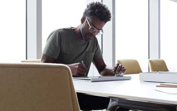 Uomo d'affari di Microsoft che lavora sul dispositivo Surface Studio