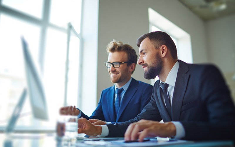 Two male colleagues looking at a PC